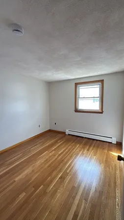 a view of a room with wooden floor and window