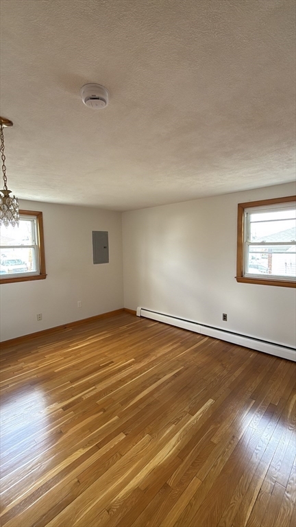 83 Pemberton Street, Unit A Revere, MA 02151 - Photo 10 of 13 an empty room with wooden floor and windows