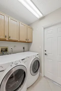 a view of a hallway with wooden floor and a chandelier fan