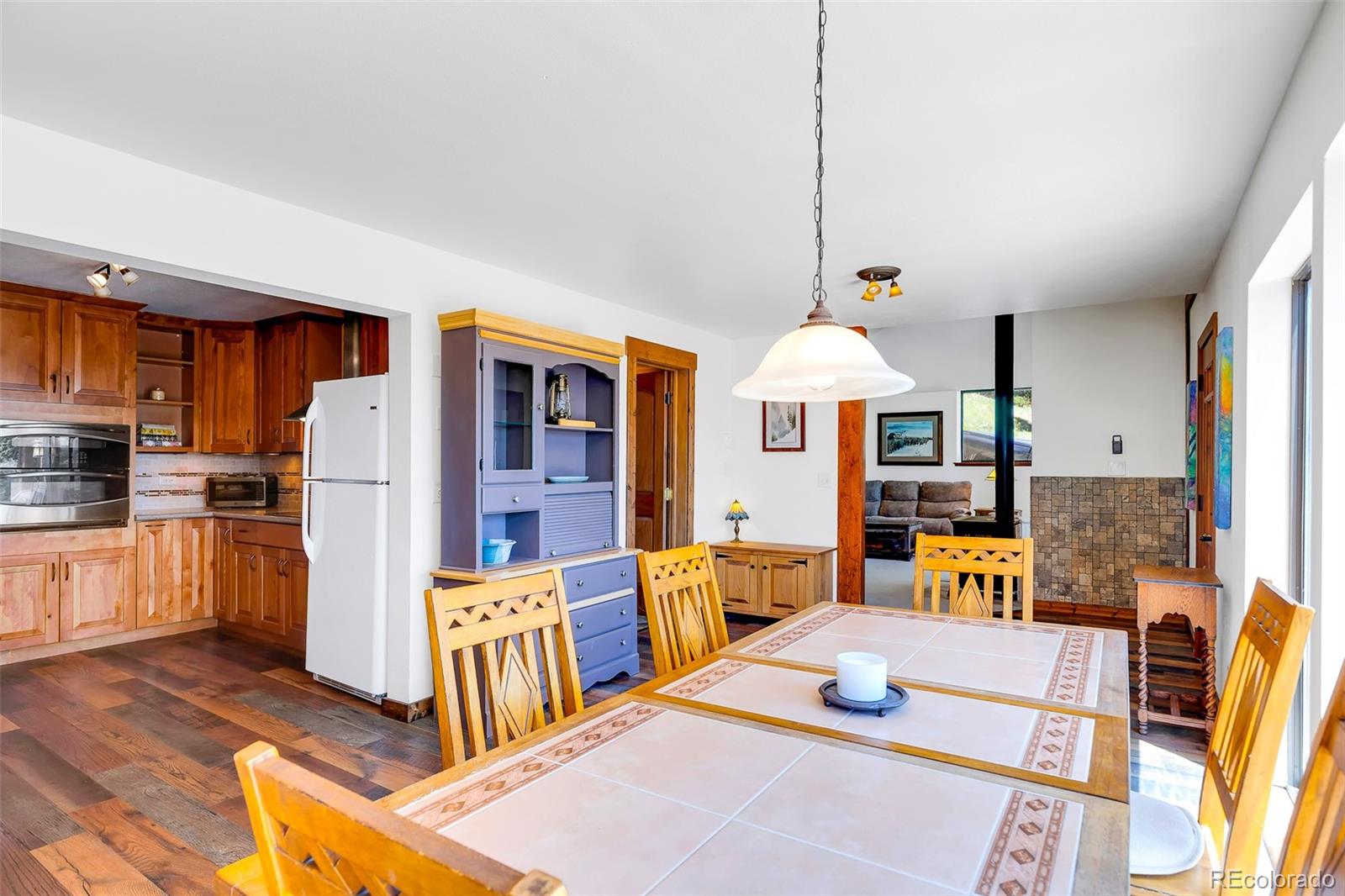60 Jackson Alma, CO 80420 - Photo 6 of 49 a kitchen with stainless steel appliances kitchen island granite countertop a refrigerator a stove a sink a dining table and chairs with wooden floor