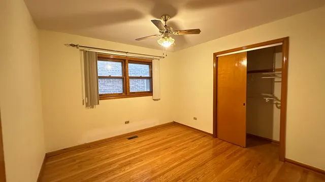 an empty room with a window and wooden floor