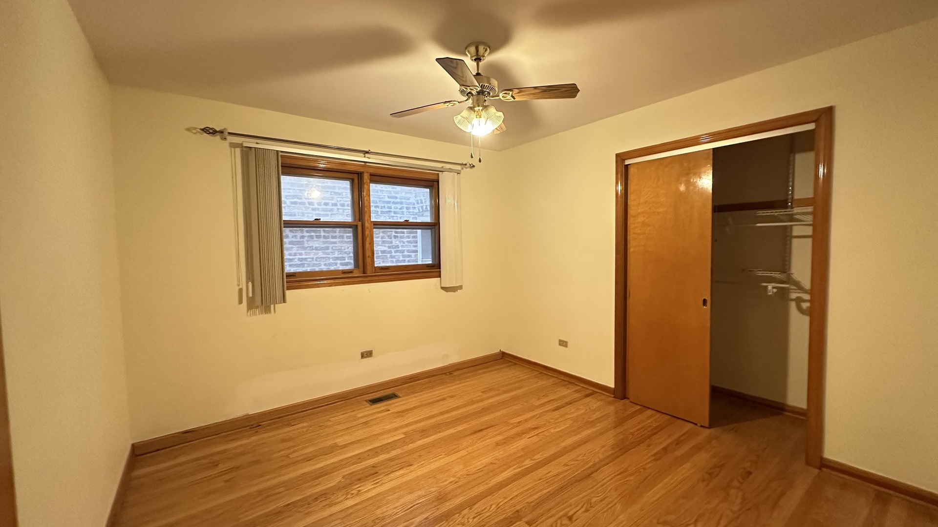5728 North McVicker Avenue, Unit 1 Chicago, IL 60646 - Photo 6 of 8 an empty room with a window and wooden floor