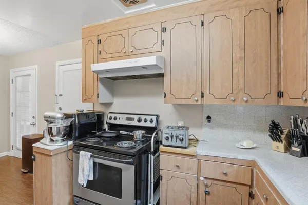 a kitchen with stainless steel appliances granite countertop a stove and a white cabinets