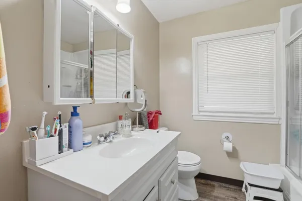 a bathroom with a sink vanity mirror and toilet