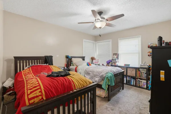 a bedroom with two beds and a ceiling fan