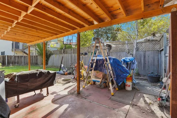 a view of a backyard with plants and wooden fence