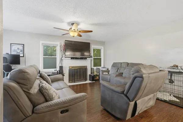 a living room with furniture a flat screen tv and a fireplace