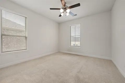 an empty room with a window and a fan