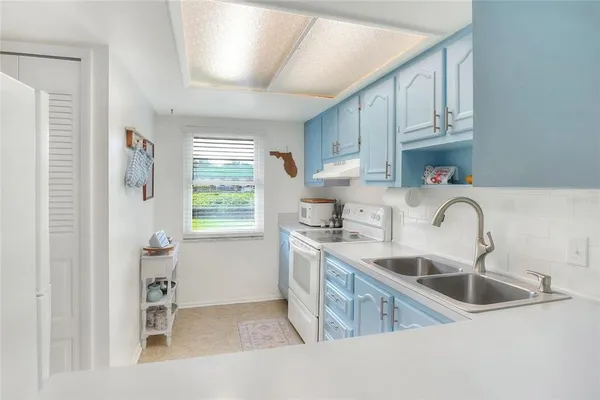 a kitchen with white cabinets and white appliances