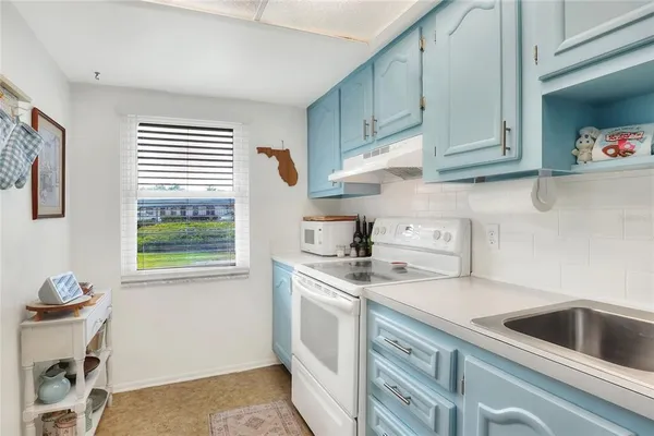 a kitchen with a sink a refrigerator and cabinets