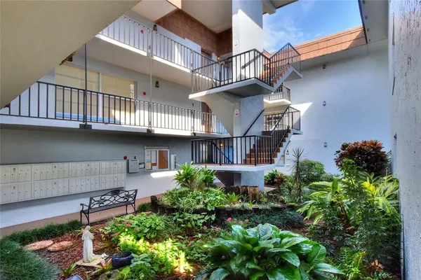 a view of a house with a yard and potted plants