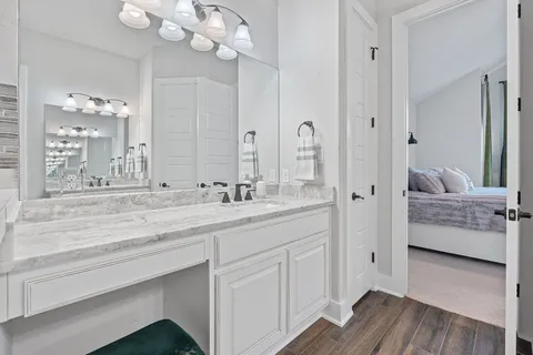 a en suite bathroom with a granite countertop sink a mirror and a shower