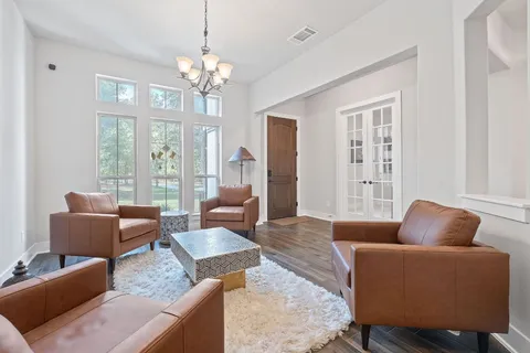 a living room with furniture a chandelier and a window
