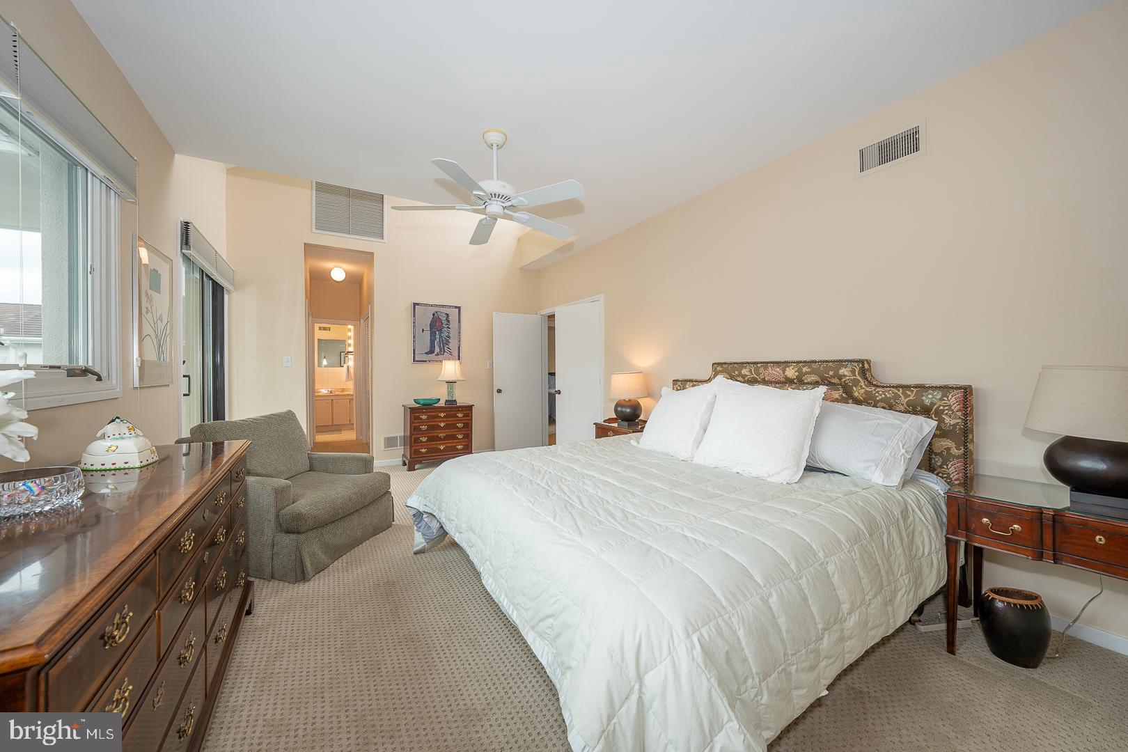 10 Brettagne, Unit 10 Devon, PA 19333 - Photo 22 of 46 a spacious bedroom with a bed a couch and a chandelier