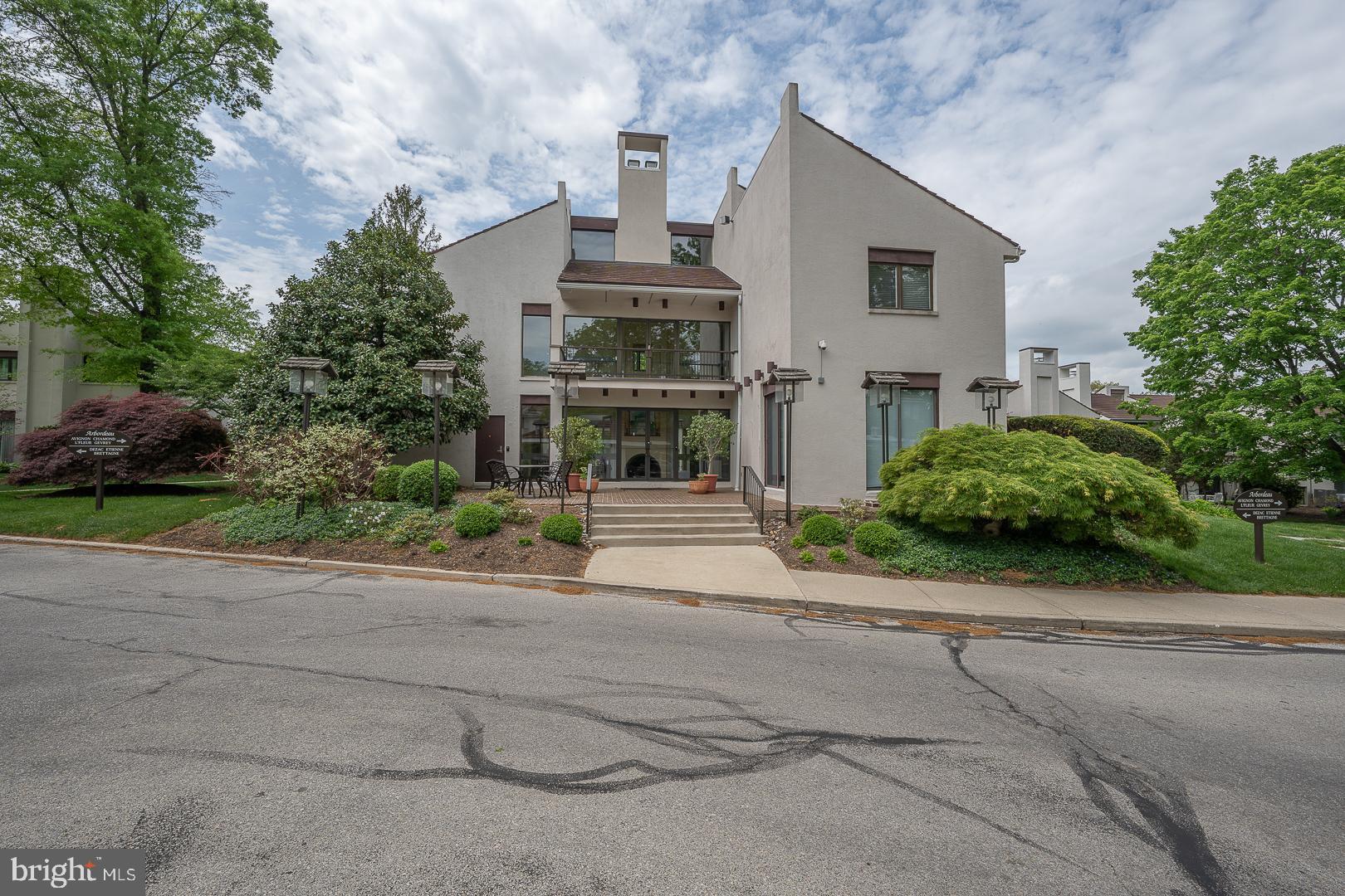 10 Brettagne, Unit 10 Devon, PA 19333 - Photo 40 of 46 a front view of a house with a yard and garage