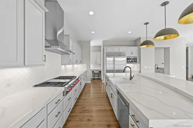 a large kitchen with stainless steel appliances granite countertop a lot of counter space and a sink