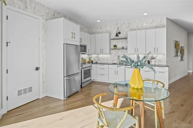 a kitchen with stainless steel appliances granite countertop a sink refrigerator and cabinets