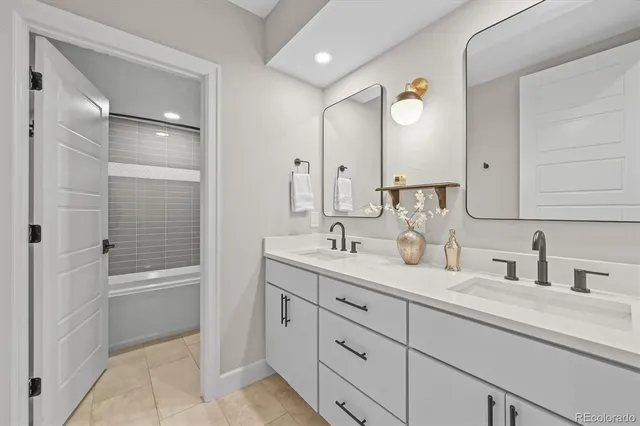 a bathroom with a double vanity sink mirror double and a bathtub