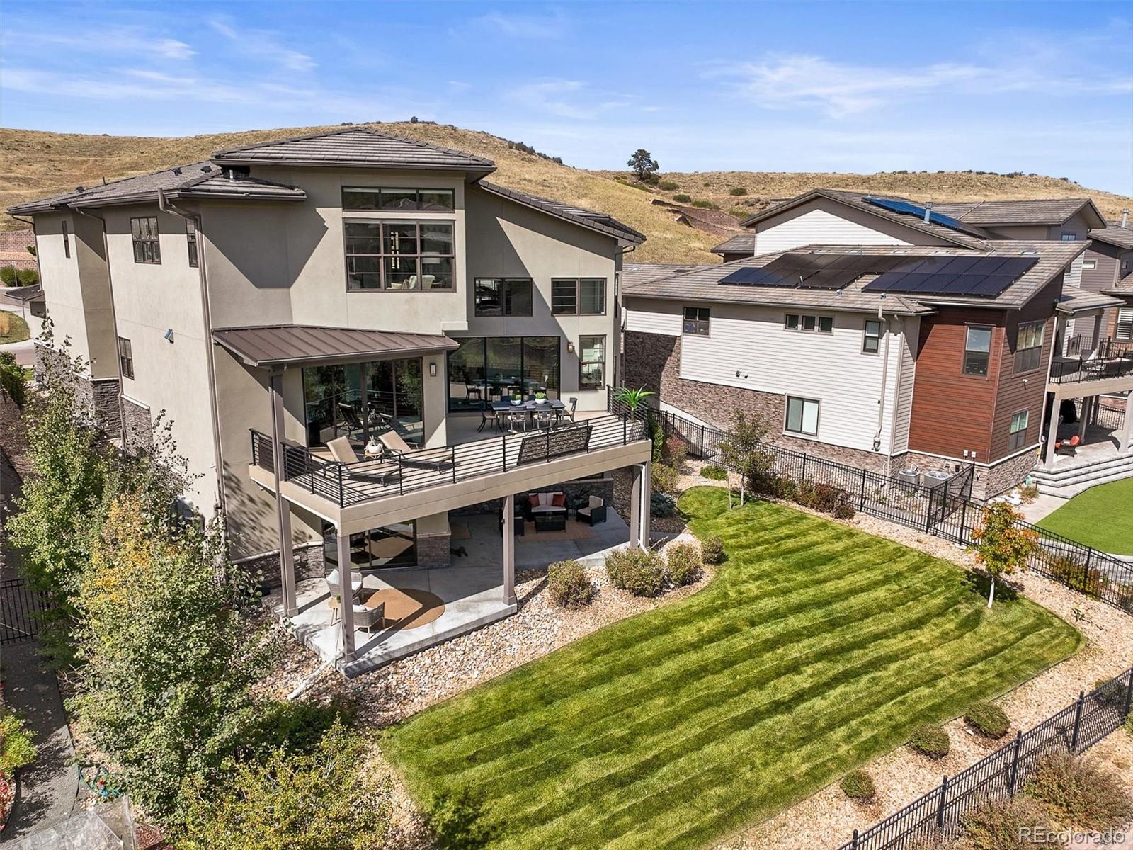 10814 Bluffside Drive Lone Tree, CO 80124 - Photo 42 of 50 a view of a white house with a small yard and wooden deck