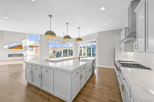 a kitchen with kitchen island granite countertop a stove and a wooden floors