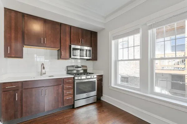 a kitchen with stainless steel appliances wooden cabinets and a stove top oven