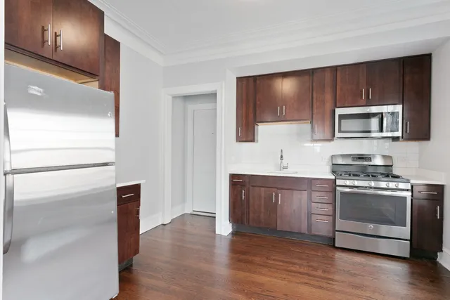 a kitchen with stainless steel appliances granite countertop a stove a sink and a refrigerator
