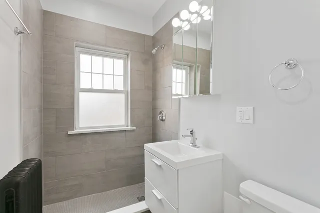 a bathroom with a sink a toilet and window