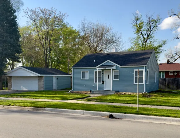 a view of a house with a big yard and large trees