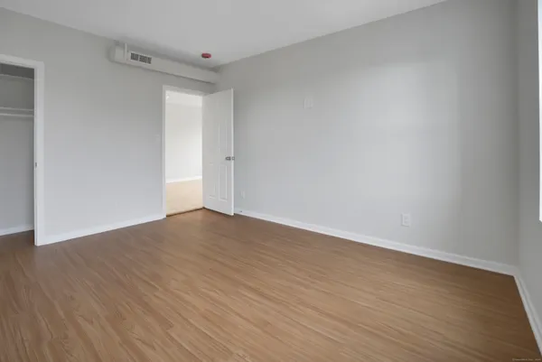 a view of an empty room with wooden floor