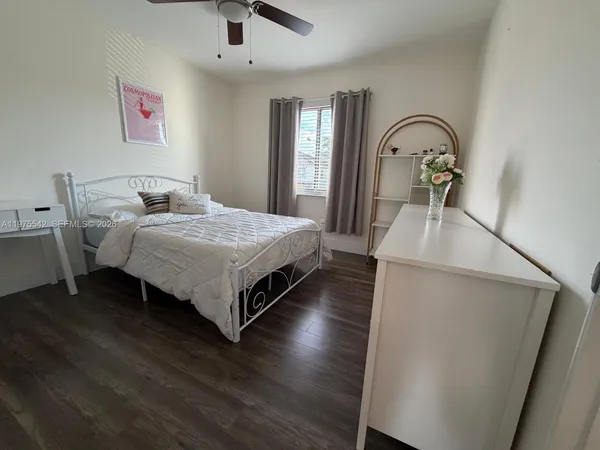 a bedroom with bed and wooden floor