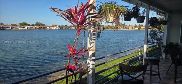 a view of a workspace with furniture and a large window