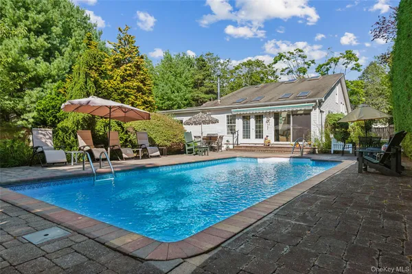 swimming pool view with a seating space and a garden view