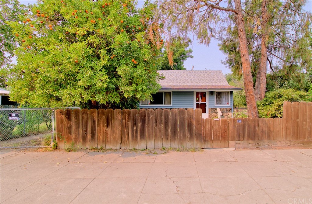 a view of a house with wooden fence next to a yard
