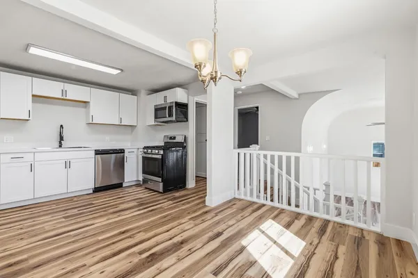 a kitchen with stainless steel appliances granite countertop a stove a microwave and a sink
