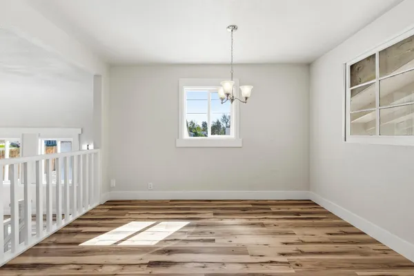a kitchen with stainless steel appliances granite countertop a stove top oven a sink dishwasher and a refrigerator with wooden floor