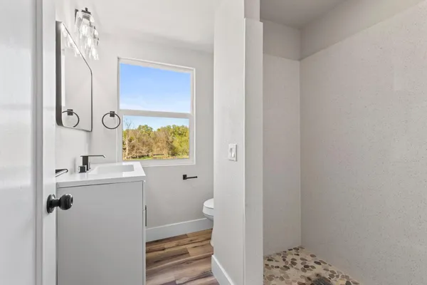 a view of empty room with window and wooden floor