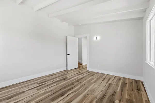 a view of an empty room with wooden floor
