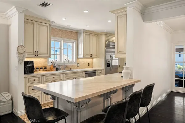 a kitchen with a table chairs sink and cabinets