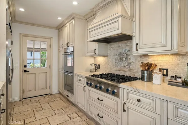 a kitchen with white cabinets and appliances