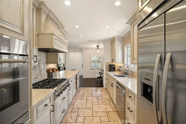 a kitchen with stainless steel appliances a refrigerator sink and stove