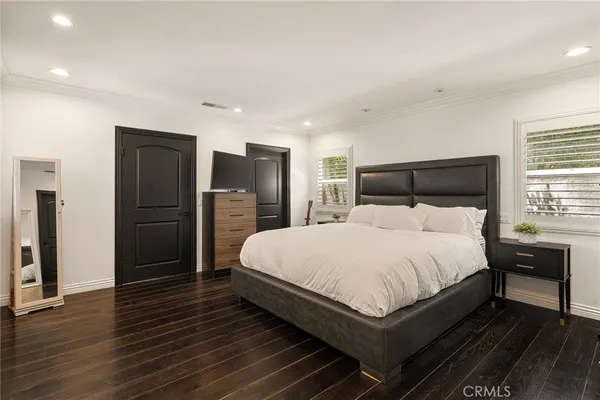 a large bed sitting in a spacious bedroom next to a window