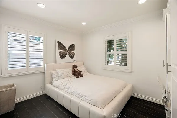 a white bed sitting in a bedroom next to a window