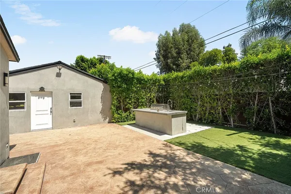 a view of a house with backyard and trees