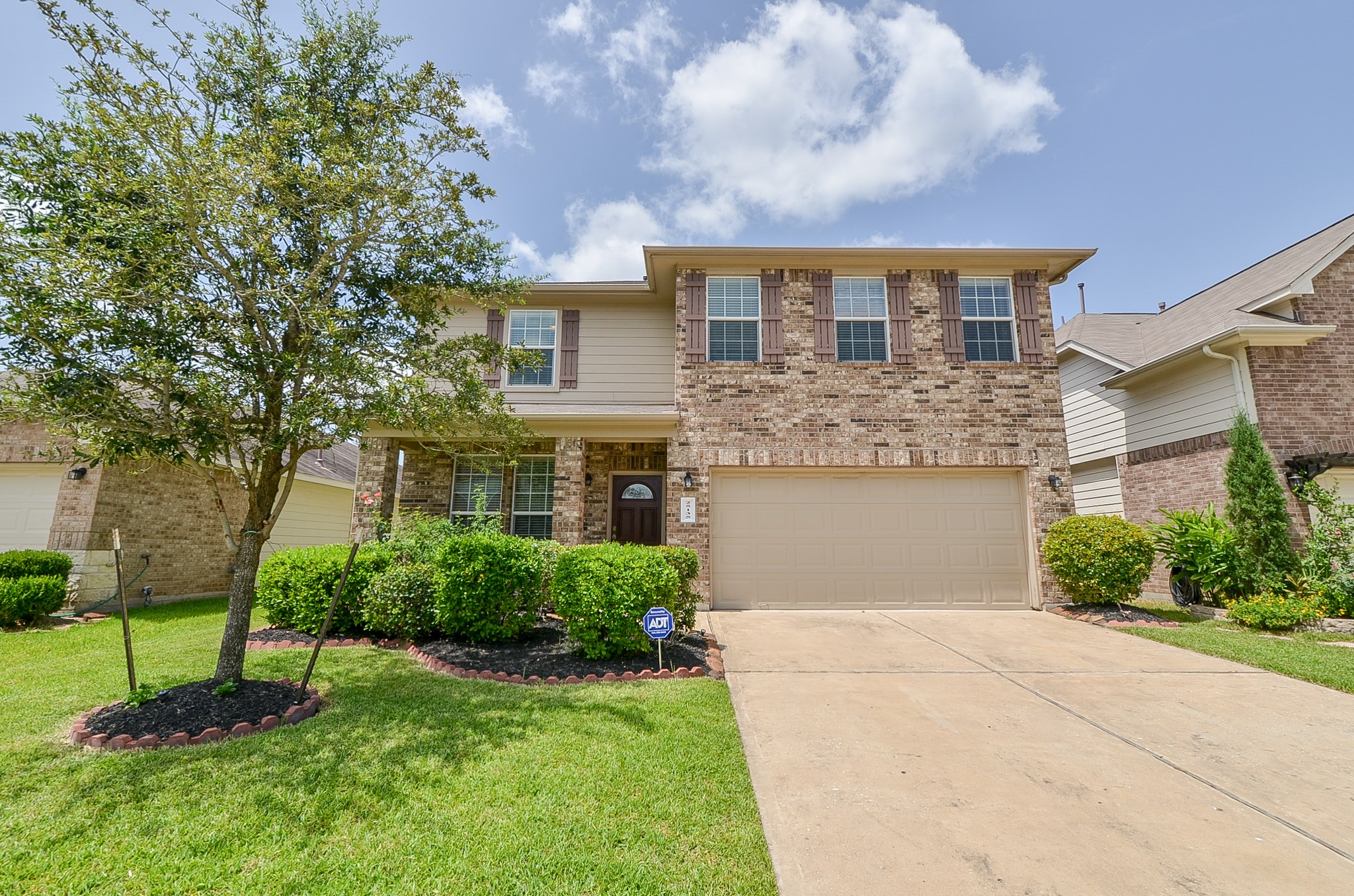 25135 Ginger Ranch Drive Katy, TX 77494 - Photo 2 of 32 Mature landscaping and a clean driveway frame the home’s classic brick-and-siding façade.