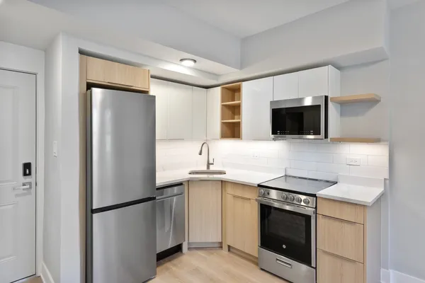 a kitchen with stainless steel appliances a refrigerator sink and microwave