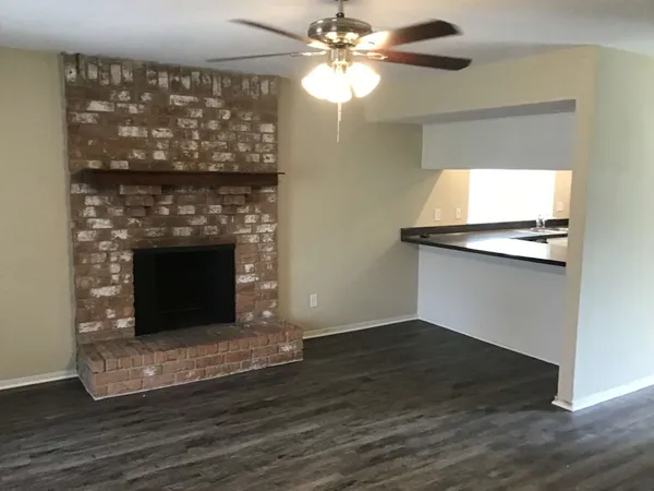 a living room with a fireplace and wooden floor