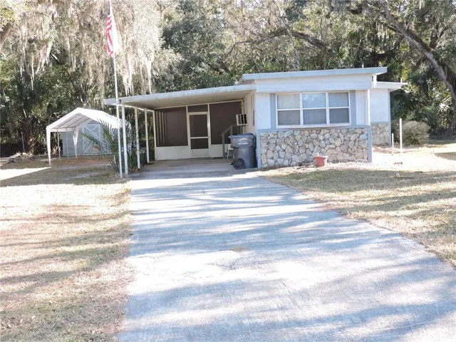 a view of a house with a patio and a yard