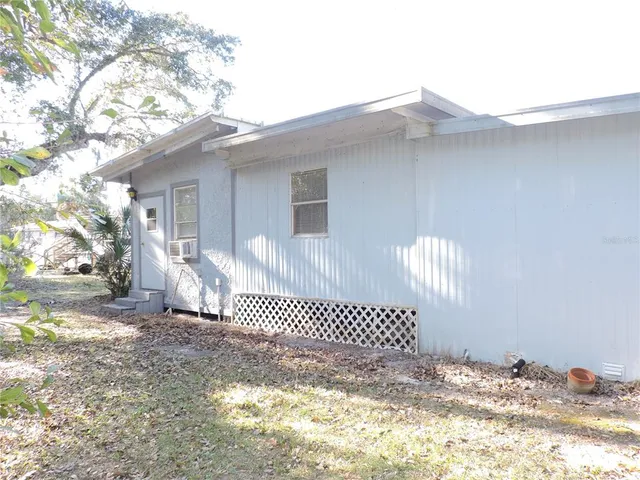 a view of a house with a yard and sitting area
