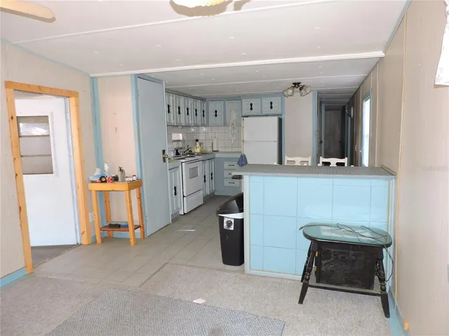 a kitchen with table chairs refrigerator and cabinets