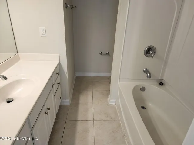 a bathroom with a tub sink and mirror